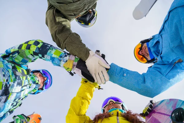 Photo du bas de jeunes snowboarders faisant poignée de main . — Photo