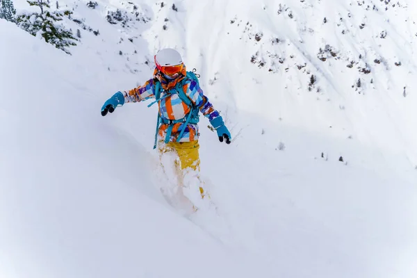 Jovem atleta menina no capacete e máscara está montando no snowboard na encosta nevada — Fotografia de Stock