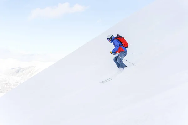 Side photo of athlete man with backpack skiing — Stock Photo, Image