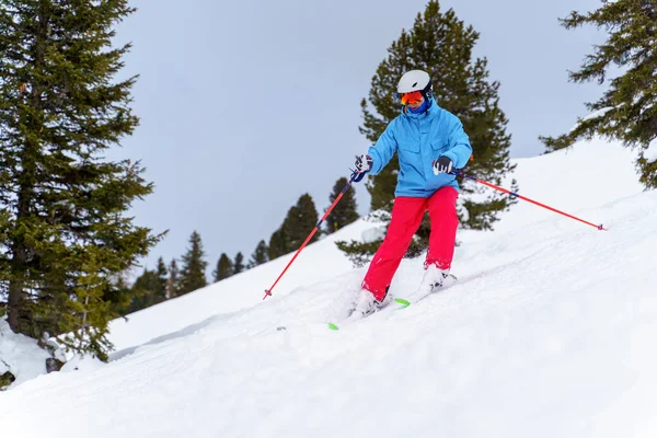 Foto de homem de esportes no capacete esqui no resort de inverno de encosta nevada — Fotografia de Stock