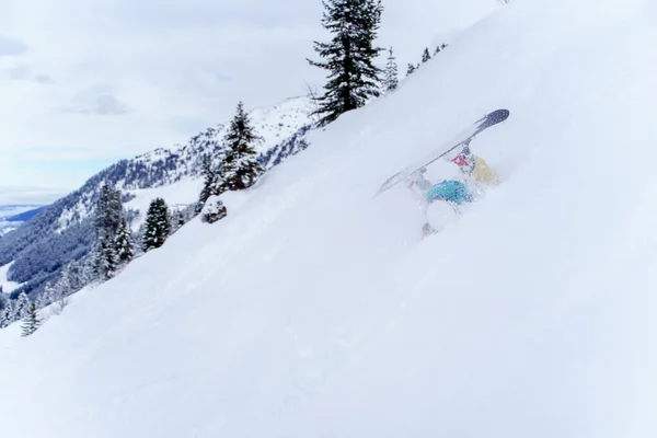 Foto de un deportista montando snowboard en la ladera nevada, las piernas pegadas —  Fotos de Stock