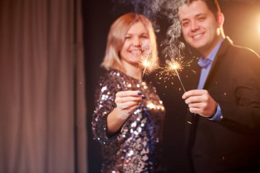 Siyah arka planda kıvılcımlar olan mutlu bir çiftin resmi