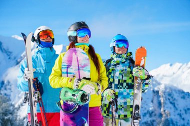 Spor yapan kadın ve kayak ve snowboard yapan erkeklerin öğleden sonra kayak merkezinde çekilmiş fotoğrafları.