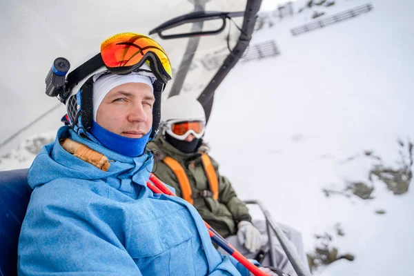 Photo de deux snowboarders en casque et masque sur téléphérique — Photo