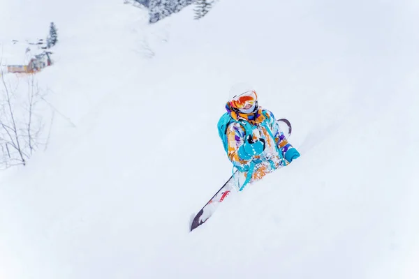 Giovane atleta sorridente seduto sulla collina nella neve nella giornata invernale — Foto Stock