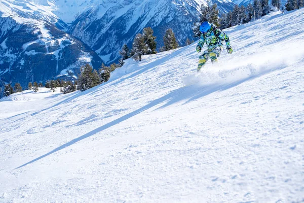 Photo of young sportsman in helmet snowboarding at winter resort. — ストック写真