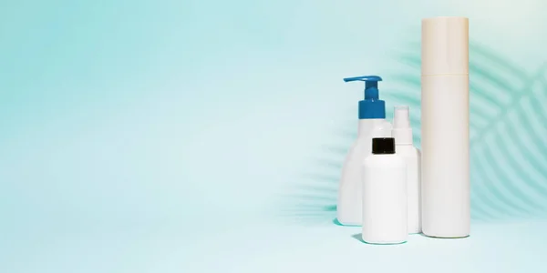 Contenitori multipli per spray, sapone liquido su fondo blu pulito — Foto Stock