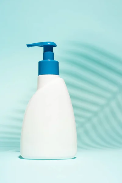 Contenitore bianco senza etichetta per sapone liquido su fondo blu pulito , — Foto Stock