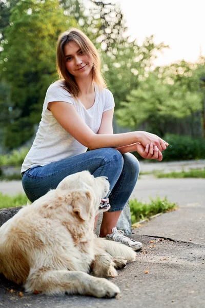 Kot pantolonlu neşeli kız yazın av köpeğiyle yürüyüşe çıkıyor. — Stok fotoğraf