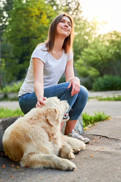 Menina alegre olhando para cima na caminhada com retriever no verão — Fotografia de Stock