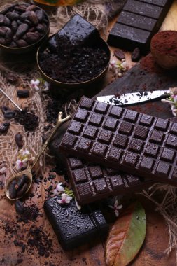Ahşap arka plan üzerinde koyu çikolata bar.