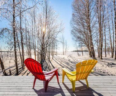 Kutup ormanda rahatlamak için büyük kırmızı ve sarı plastik şezlong şezlong.