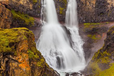 Art arda sıralı güçlü streams düşüyor soğuk kayalar, İzlanda karşı kırma kükreme ile.