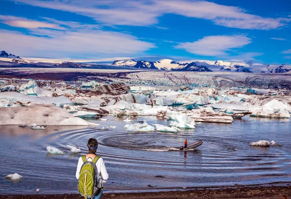 女性游客与绿色背包看日出在冰礁湖 — 图库照片