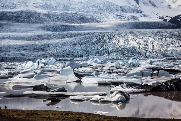 Beach siyah ve kahverengi buz parçaları, İzlanda ile kaplı kum.