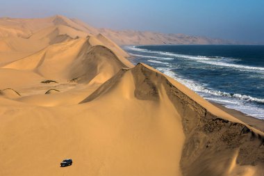  Büyülü jeep safari aracılığıyla kumulları okyanus kıyısında, Atlantic coast Namibya, Güney Afrika.