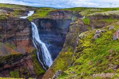 Yüksek şelale Hayfoss pitoresk ve tehlikeli tundra kanyon. İzlanda'daki kasvetli sisli Temmuz günü. Aşırı ve phototourism kavramı