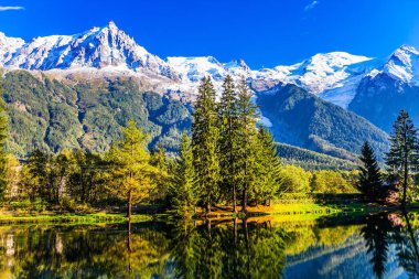 Gölün pürüzsüz soğuk suda Alpler ve iğne yapraklı park karla kaplı dağ doruklarına yansıtır. Dağ tatil Chamonix. Etkin kış turizm kavramı
