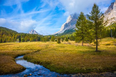 Ekolojik ve aşırı Turizm kavramı. Soğuk hızlı bahar vadi boyunca akar. Baş döndürücü Dolomites. Keskin kayalara çimenli vadileri çevreleyen