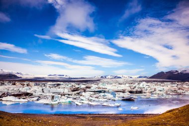 Buz Lagoon Sunrise. Buz buz Lagoon - Jokulsarlon drift. Buzlar yumuşak su yüzeyine yansıtılır. Aşırı Kuzey Turizm kavramı