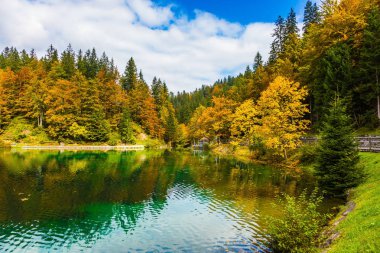 Su bulutlu gökyüzü ve çok renkli ormanlar yansıtır. Sessiz gölün kuzey İtalya, Lago de Fusine. Kültürel ve ekolojik turizm kavramı