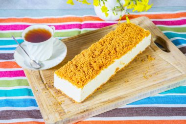 Profesyonel fırını. Papatya ve porselen fincan sıcak çay ile vazo. Beyaz peynirli kek, tatlı kırıntıları ile serpilir