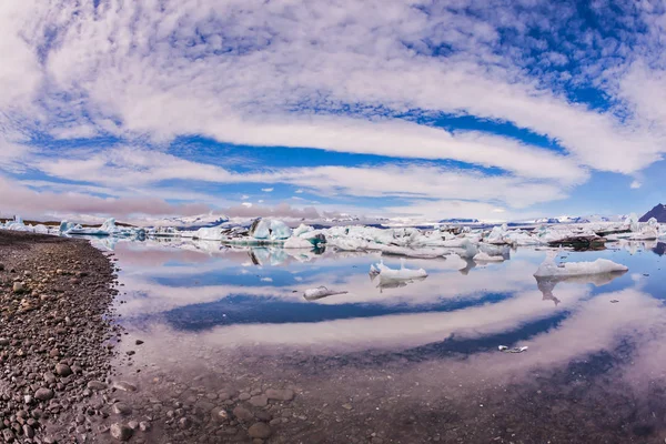 Jokulsarlon 的发光冰山游行 带条纹的云彩在泻湖的光滑的水中美丽地反射 北方极端旅游的概念 — 图库照片