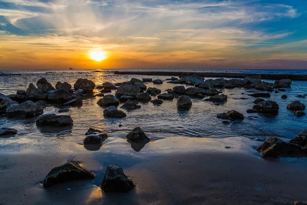 津波で砂浜で大きな石 カイサリアで地中海の海岸の明るい夕日 イスラエルの暖かい冬 生態学的な観光事業の概念 — ストック写真