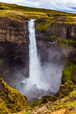 İzlanda kasvetli Temmuz günü. Yüksek şelale Hayfoss pitoresk ve tehlikeli tundra Kanyon.