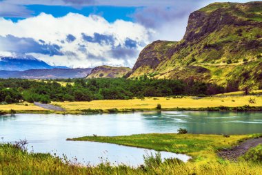 Yaz aylarında Güney Şili. Torres del Paine Millî Parkı. Rio Paine - sessiz nehir akışı pitoresk tepeler arasında. Aşırı ve aktif Turizm kavramı