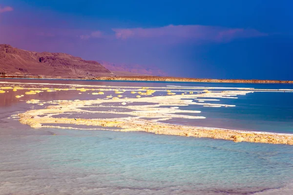 Therapeutic Dead Sea. The evaporated salt is precipitated by picturesque stripes in shallow water. The concept of medical and ecological tourism. Israel