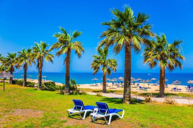 Kıbrıs Adası Akdeniz'de yaz tatili. İki şezlong üzerinde bir güneşli glade ayarlanır. Turizm ve plaj dinlenme iyileştirme kavramı