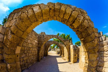 Gezi arkeolojik Park bir Roma İmparatorluğu için. Kemerli geçit - Caesarea bağlantı noktası kapalı sokak. Güneşli bir bahar günü. İsrail. Ekolojik ve tarihsel turizm kavramı