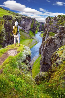 Yaşlı kadın bir kayada duran ve doğal peyzaj Fotoğrafçılık. Aktif Kuzey Turizm kavramı. İzlanda çarpıcı kanyonda. Yaz aylarında yeşil Tundra