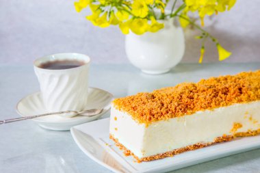  Muhteşem beyaz peynirli kek, tatlı kırıntıları ile serpilir. Profesyonel fırını. Porselen fincan sıcak çay ve papatya ile vazo