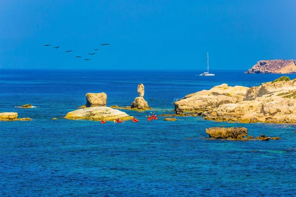oarsmen on red canoe. Island of Cyprus in Mediterranean Sea