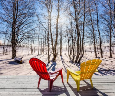 Ormanda rahatlamak için rahat kırmızı ve sarı plastik şezlong. Arctic gün batımı. Ufukta Güneş parlar düşük. Aşırı ve Eko-Turizm Turizm kavramı