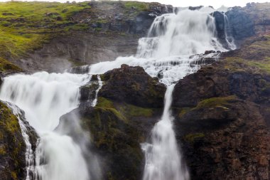 İzlanda'daki yağışlı ve soğuk Temmuz. Art arda sıralı Falls bir kükreme ile güçlü akarsu bir uçurum düşmek. Aktif ve aşırı Turizm kavramı