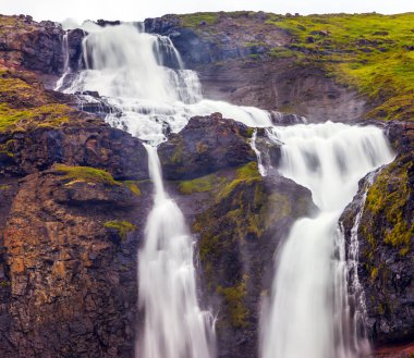 Aktif ve aşırı Turizm kavramı. İzlanda'daki yağışlı Temmuz. Art arda sıralı Falls bir kükreme ile güçlü akarsu bir uçurum düşmek