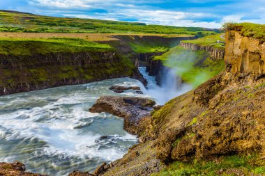 Tundra gün güneşli yaz. Şelale İzlanda - Hvitau Nehri üzerinde Gullfoss. Su büyük kitleler dar bir geçit gürültüyle çarpmak. Aşırı ve phototourism kavramı