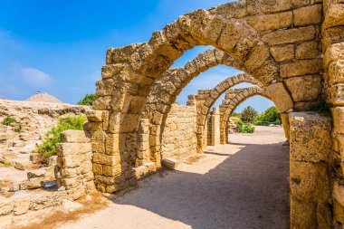  Güneşli bir bahar günü. Kemerli geçit - Caesarea bağlantı noktası kapalı sokak. Caesarea antik kentin kalıntıları. İsrail. Ekolojik ve tarihsel turizm kavramı