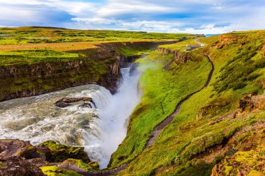 İzlanda'daki fantastik Golden şelale Gulfoss. Rüzgarlı ve güneşli yaz günü. Sahilde turistler için bir yoldur. Aşırı ve phototourism kavramı