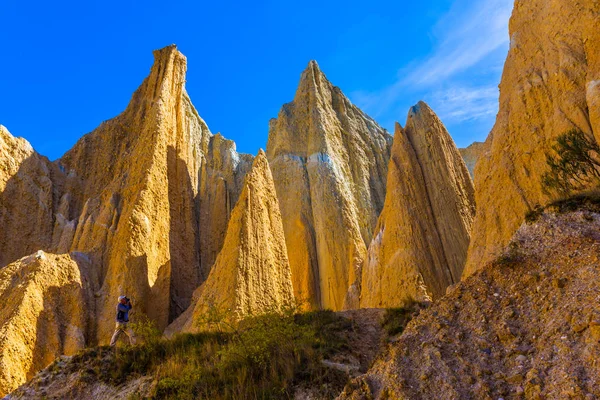 老人在峡谷里拍照 粘土悬崖是高大的尖顶 由狭窄的峡谷隔开 前往新西兰 生态和摄影旅游的概念 — 图库照片