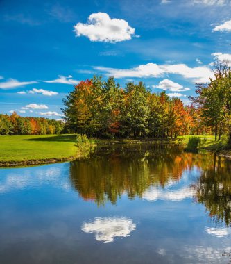 Golf Club, Fransızca Kanada. Kırmızı, turuncu ve yeşil sonbahar yaprakları Gölü nün su temizlemek için yansıtılır. Park fantastik güzellik. Golf Turizmi kavramı