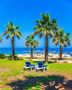 Akdeniz üzerinde bekletin. İki şezlong üzerinde bir güneşli glade ayarlanır. Bir tatil beldesi tropikal doğada. Turizm ve plaj rekreasyon sağlık kavramı. 