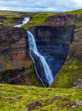 Tehlikeli ve pitoresk tundra Kanyon yüksek şelale Hayfoss. İzlanda bulutlu ve sisli Temmuz günü. Aşırı ve phototourism kavramı