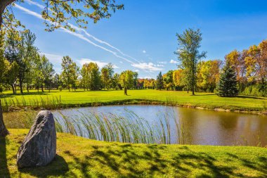 Küçük Gölet bir kil alt ile sazlık tarafından çevrilidir. Yeşil çim çim ve ağaçların. Eğlence Turizm kavramı. Güneşli bir gün Fransız Kanada'da parlayan