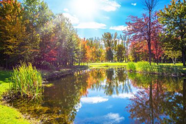  Golf Kulübü Bromont, Fransızca Kanada giden yolda. Park fantastik güzellik. Golf turizmi kavramı. Kırmızı, turuncu ve sarı yapraklar Gölü temizlemek için yansıtılır
