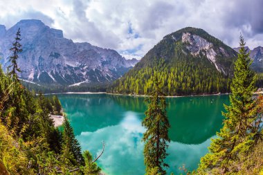 Yürüyüş ve eko-turizm kavramı. Yeşil su çevredeki orman ve dağlar yansıtır. Muhteşem göl Lago di Braies, South Tyrol, İtalya