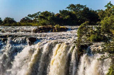 Grand Victoria Şelalesi. Victoria, Güney Afrika 'daki Zambezi Nehri üzerinde bir şelaledir. Thundering Smoke Ulusal Parkı Zambiya 'da. Zambiya ve Zimbabwe sınırı. Yağmurdan sonraki yüksek mevsimde harika bir yürüyüş. Aktif, ekstrem ve fotoğraf turnuvası kavramı